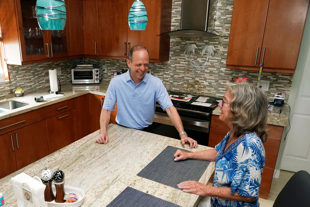 Mark Bendell and his wife Laurie talk in their kitchen, Monday, May 23, 2022, in Boca Raton, Fla. (AP Photo/Marta Lavandier)