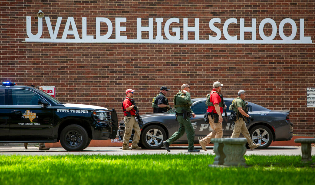 Police walk outside Uvalde High School after shooting a was reported earlier in the day at Robb Elementary School, Tuesday, May 24, 2022, in Uvalde, Texas. (William Luther/The San Antonio Express-News via AP)