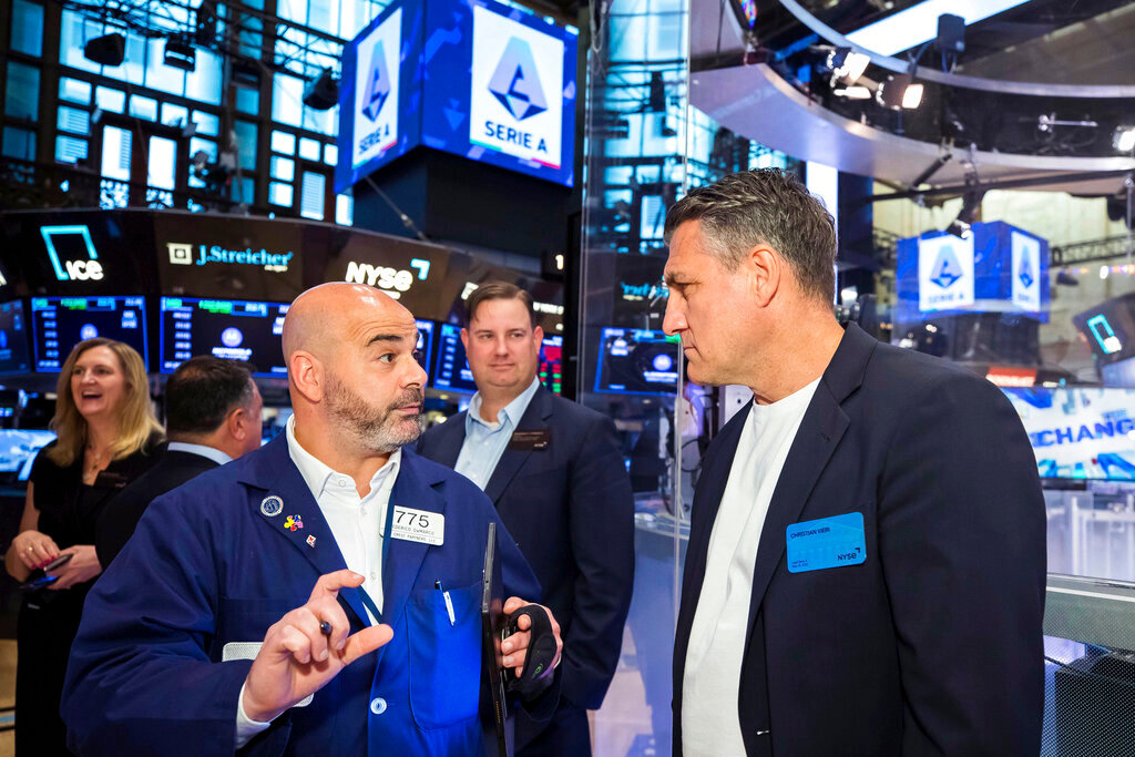 Trader Fred DeMarco, left, talks with Christian Vieri, right, on the trading floor during the visit of a delegation of Lega Serie A executives and owners to the NYSE, Tuesday, May 24, 2022. (Courtney Crow/New York Stock Exchange via AP)