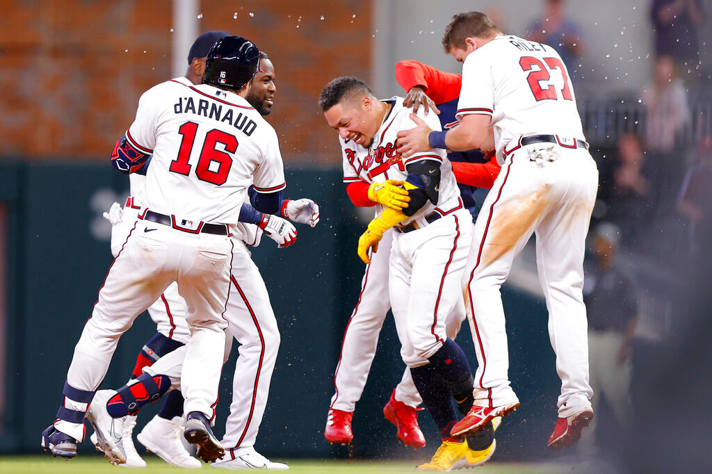 Atlanta Braves' William Contreras is mobbed by teammates after his game-winning single in the ninth inning of against the Philadelphia Phillies, Tuesday, May 24, 2022, in Atlanta. (AP Photo/Todd Kirkland)