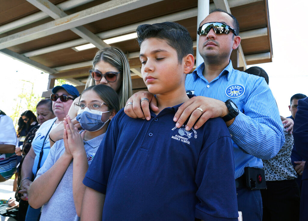 Omahar Padillo holds on to his son Omahar Jr., 12, during a community prayer service for the shooting victims at Robb Elementary in Uvalde on Wednesday, May 25, 2022, in Pharr, Texas.