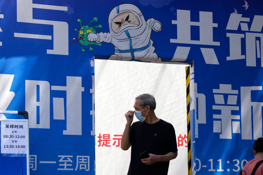 A resident leaves from a mass COVID test site, Friday, May 27, 2022, in Beijing. (AP Photo/Ng Han Guan)