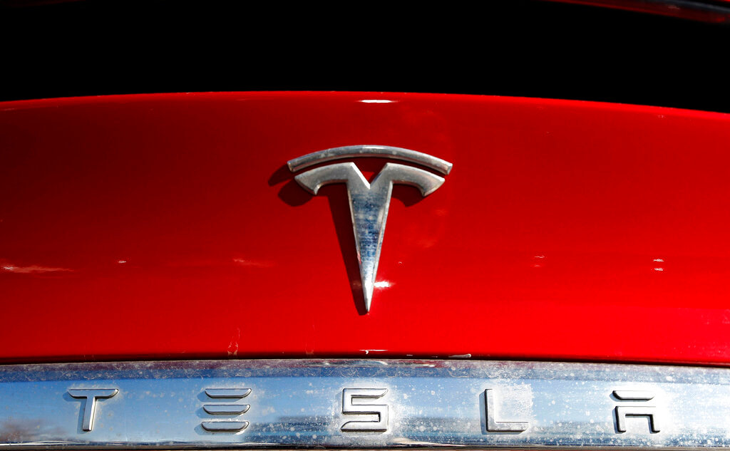 The Tesla logo on a 2020 Model X at a Tesla dealership in Littleton, Colo.  (AP Photo/David Zalubowski, File)