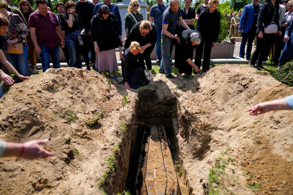 Relatives of Army Col. Oleksander Makhachek mourn during his funeral in Zhytomyr, Ukraine, Friday, June 3, 2022. According to comrades, Makhachek was killed when a shell landed on his position on May 30. (AP Photo/Natacha Pisarenko)