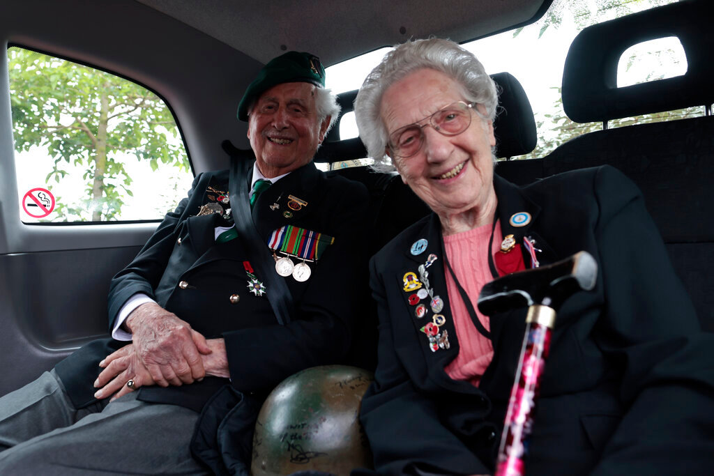British veterans Roy Maxwell and Mary Scott arrive in a British Taxi Charity for Military Veterans to the ceremony at Pegasus Bridge, in Ranville, Normandy, Sunday, June, 5, 2022. (AP Photo/Jeremias Gonzalez)
