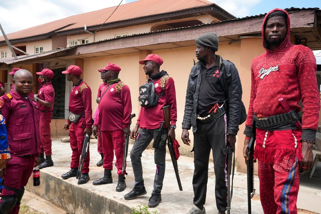 Armed vigilantes stand guard outside the St Louis Catholic hospital in the town of Owo, Nigeria, Monday, June 6, 2022. (AP Photo/Sunday Alamba)