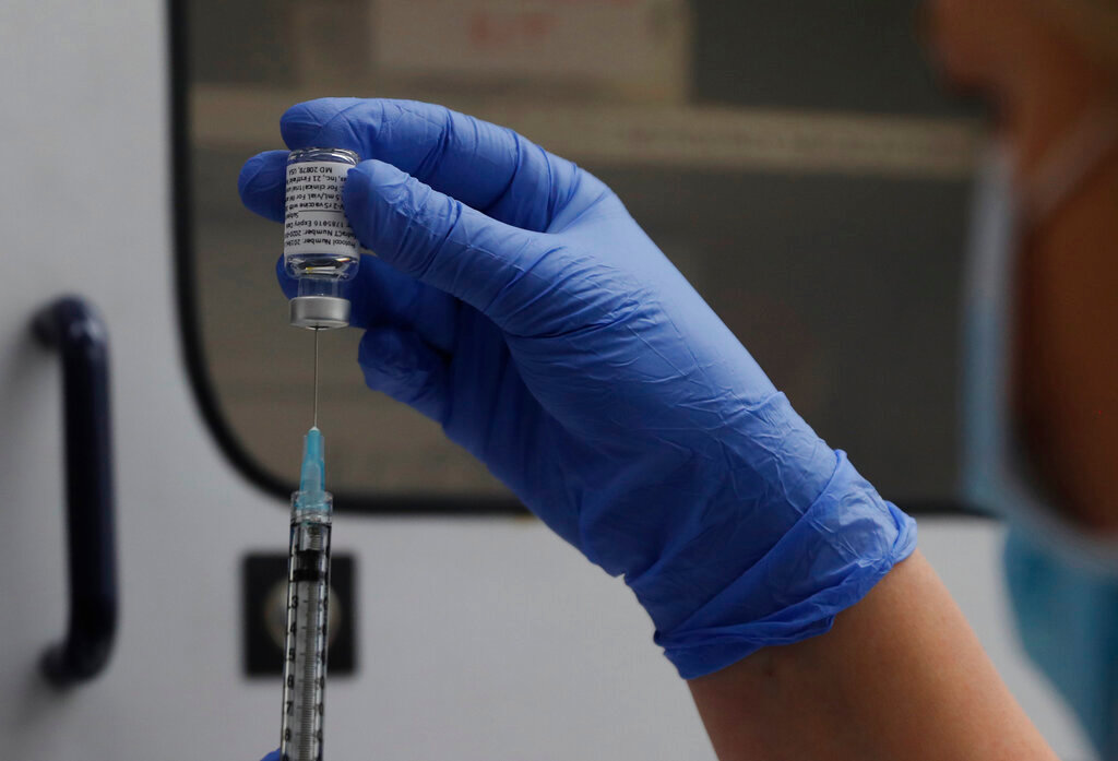 A vial of the Phase 3 Novavax coronavirus vaccine is readied for use in the trial at St. George's University hospital in London, Oct. 7, 2020. (AP Photo/Alastair Grant, File)
