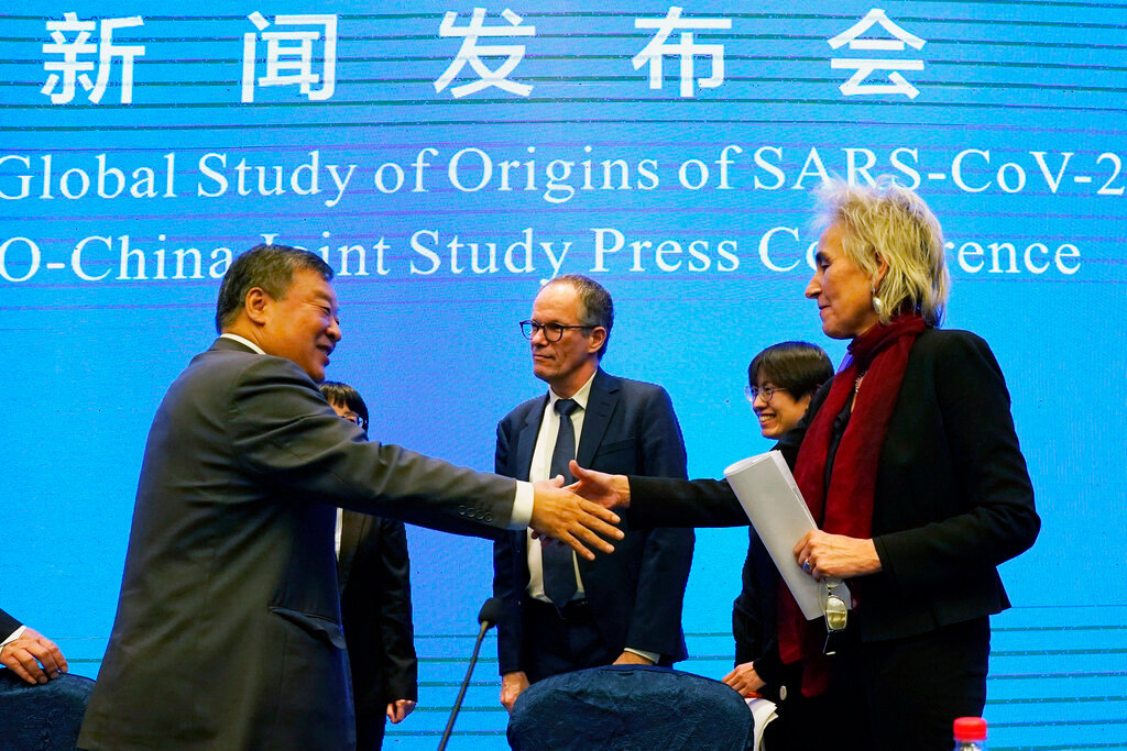 Marion Koopmans, right, and Peter Ben Embarek, center, of the World Health Organization team say farewell to their Chinese counterpart Liang Wannian, left, after a WHO-China Joint Study Press Conference at the end of the WHO mission in Wuhan, China on Feb. 9, 2021. (AP Photo/Ng Han Guan, File)