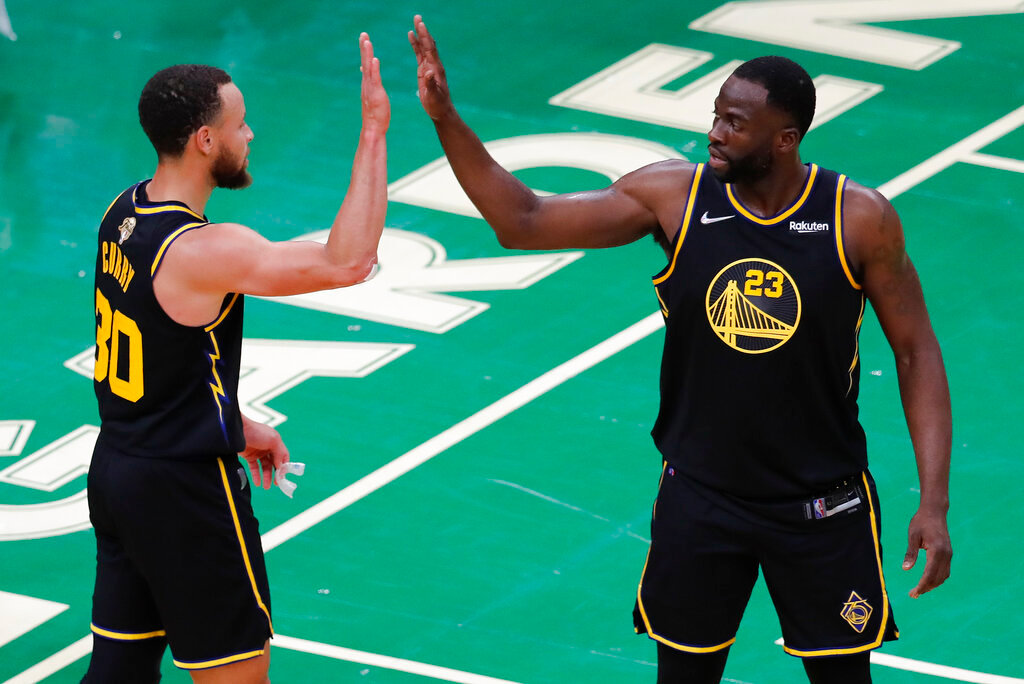 Golden State Warriors guard Stephen Curry (30) and forward Draymond Green (23) high five during the fourth quarter of Game 4 of the NBA Finals against the Boston Celtics, Friday, June 10, 2022, in Boston. (AP Photo/Michael Dwyer)