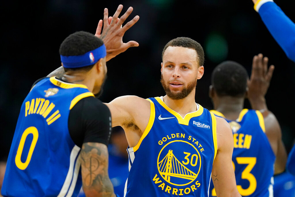 Golden State Warriors guard Stephen Curry (30) high fives Golden State Warriors guard Gary Payton II (0) during the second quarter of Game 6 of the NBA Finals against the Boston Celtics, Thursday, June 16, 2022, in Boston. (AP Photo/Steven Senne)