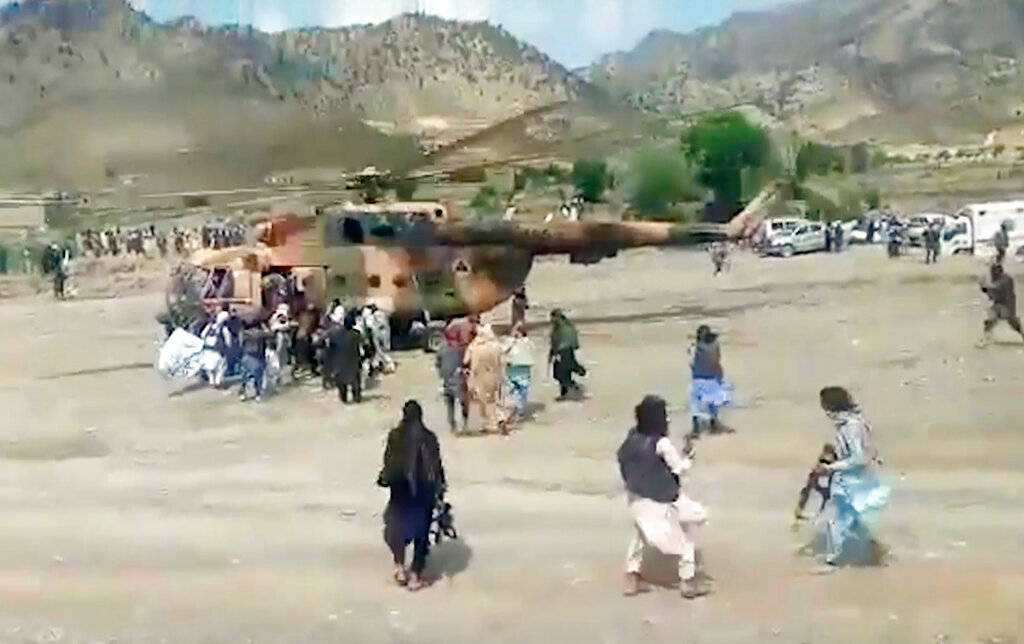 Taliban fighters secure a government helicopter to evacuate injured people in Gayan district, Paktika province, Afghanistan, Wednesday, June 22, 2022. (Bakhtar State News Agency via AP)
