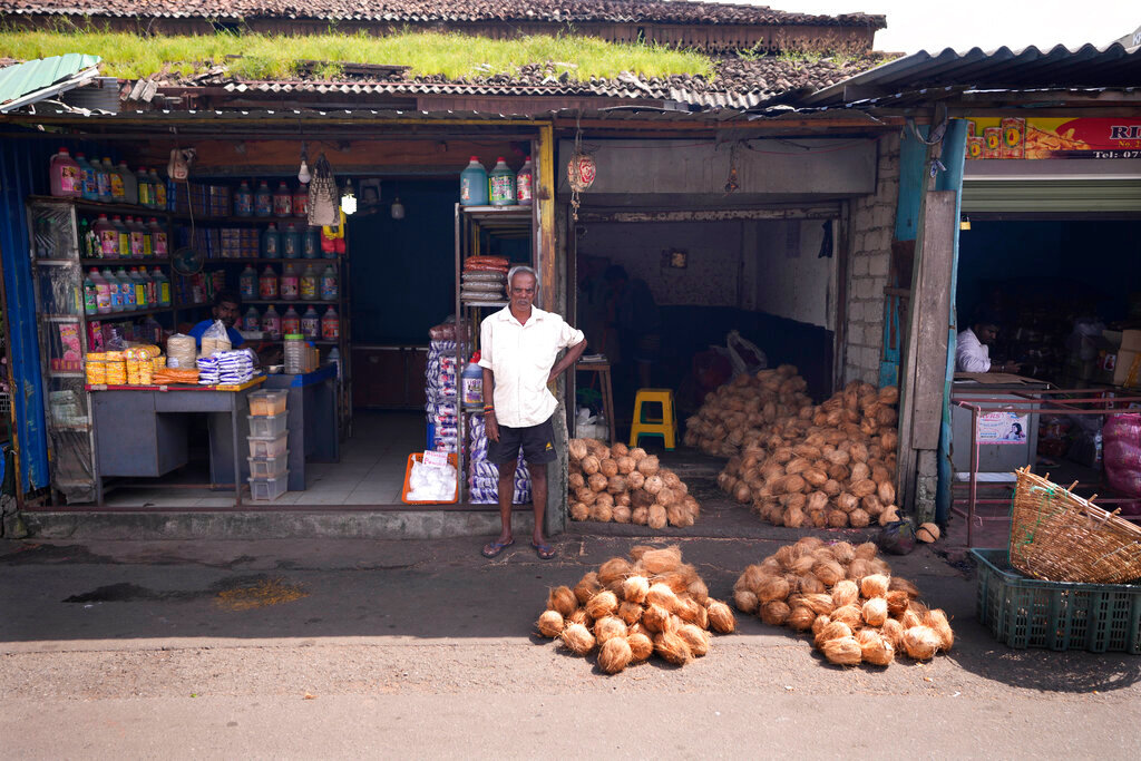 A coconut seller waits for customers at a market place in Colombo, Sri Lanka, Friday, June 10, 2022. (AP Photo/Eranga Jayawardena)