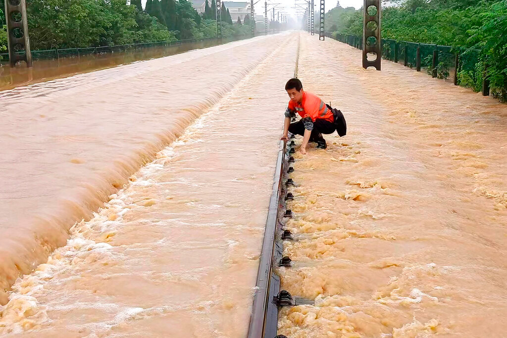A worker checks a section of flooded railway in Shangrao in central China's Jiangxi province, Tuesday, June 21, 2022. (Chinatopix via AP)