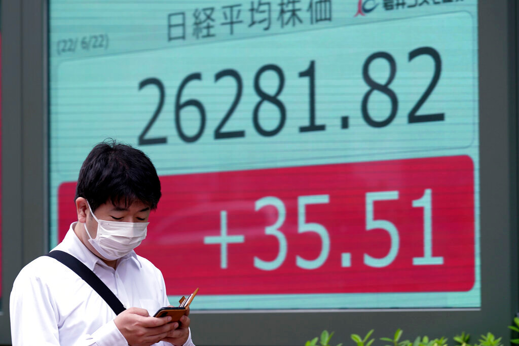A man walks in front of an electronic stock board showing Japan's Nikkei 225 index at a securities firm Wednesday, June 22, 2022, in Tokyo. (AP Photo/Eugene Hoshiko)