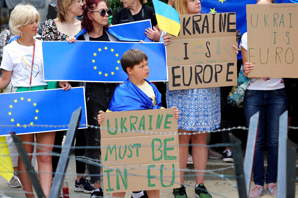 Protestors in support of Ukraine stand with signs and EU flags during a demonstration outside of an EU summit in Brussels, Thursday, June 23, 2022. (AP Photo/Olivier Matthys)