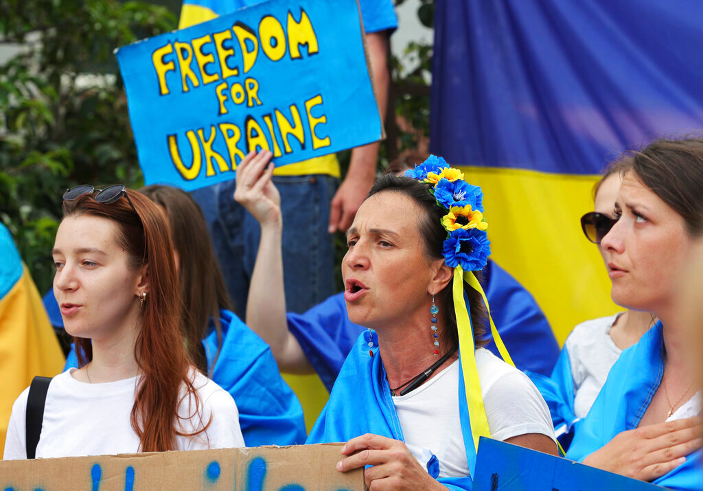 Protestors in support of Ukraine stand with signs and flags during a demonstration outside of an EU summit in Brussels, Thursday, June 23, 2022. (AP Photo/Olivier Matthys)