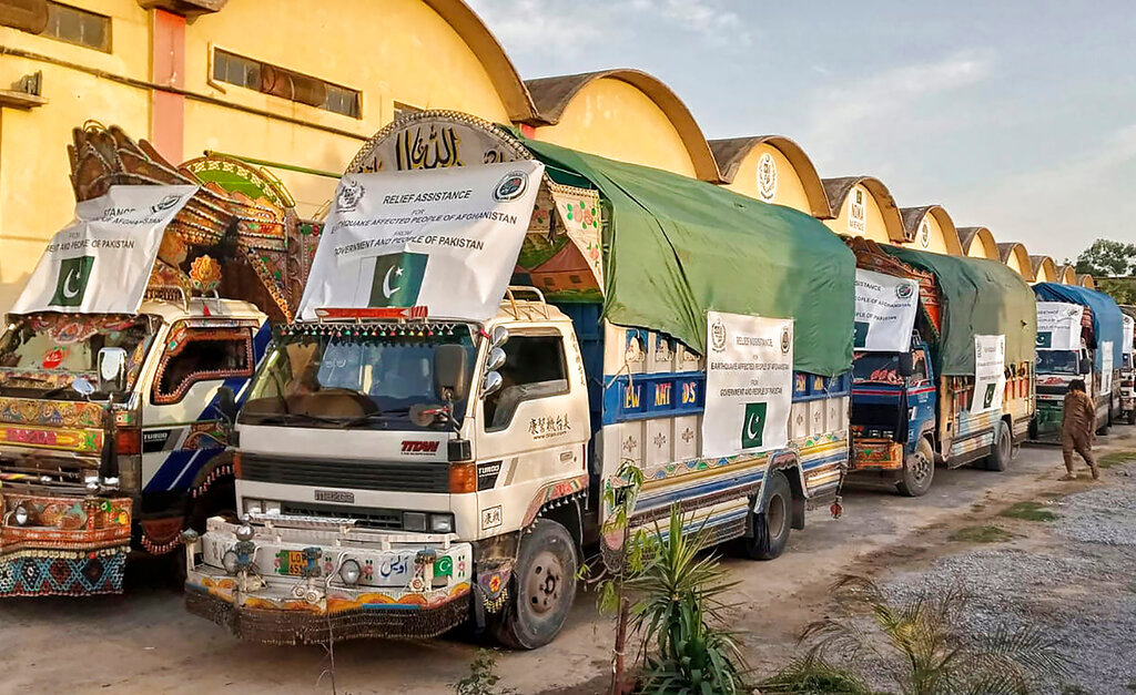A convoy of trucks carrying relief good including tents, blankets and emergency medicines for Afghanistan's earthquake hit areas, prepare to leave for Afghanistan at a warehouse in Islamabad, Pakistan, Thursday, June 23, 2022. (National Disaster Management Authority via AP)