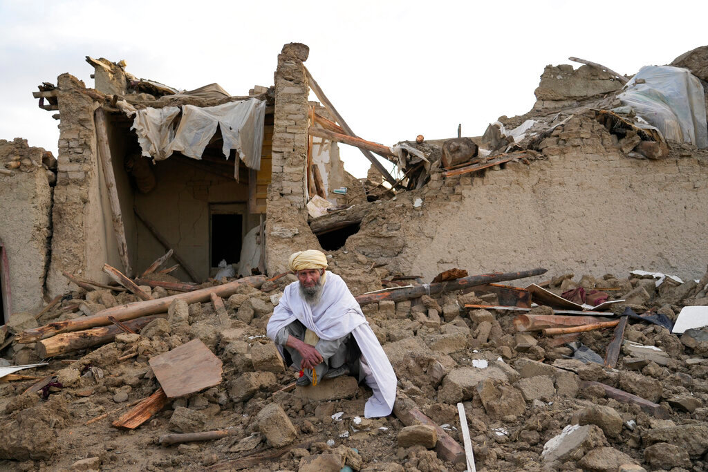 An Afghan sits by the rubble of his house earthquake in Gayan village, in Paktika province, Afghanistan, Thursday, June 23, 2022. (AP Photo/Ebrahim Nooroozi)