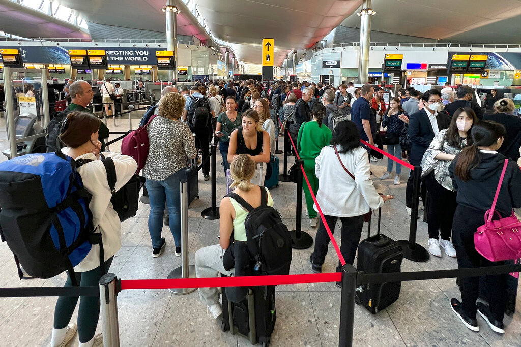 Travelers wait in line at security at Heathrow Airport in London, Wednesday, June 22, 2022.  (AP Photo/Frank Augstein)