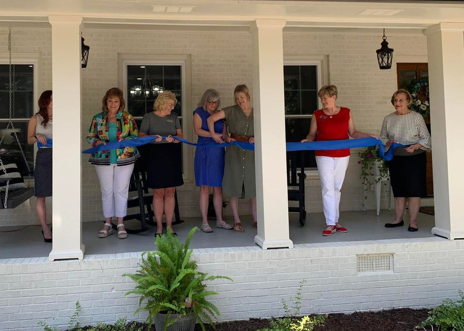 Beth Hathorn, blue dress, Executive Director of the Whispering Hope Women’s Resource and Pregnancy Center, cuts the ribbon to officially open the Living Hope Supportive Maternal Residence.