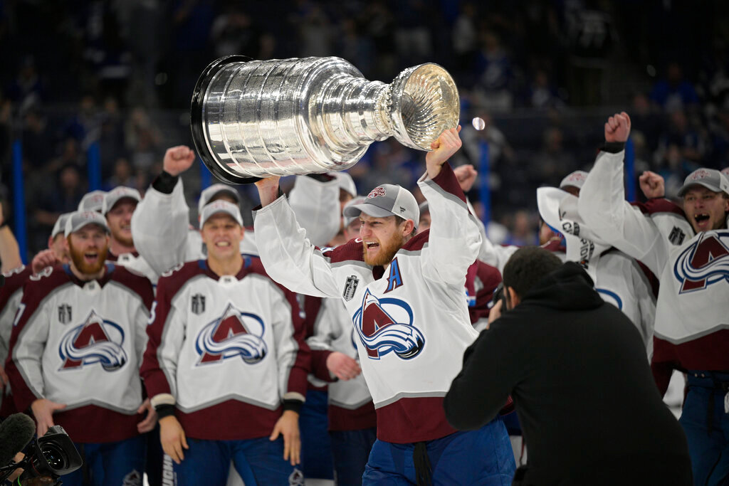 Colorado Avalanche center Nathan MacKinnon lifts the Stanley Cup after the team defeated the Tampa Bay Lightning on Sunday, June 26, 2022, in Tampa, Fla. (AP Photo/Phelan Ebenhack)