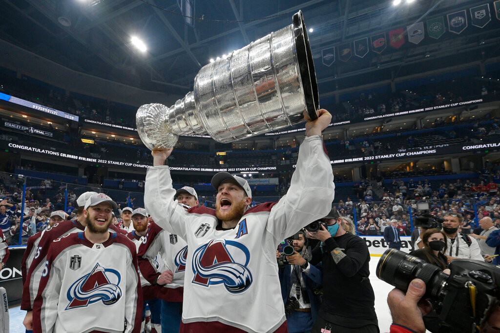 Colorado Avalanche center Nathan MacKinnon lifts the Stanley Cup after the team defeated the Tampa Bay Lightning on Sunday, June 26, 2022, in Tampa, Fla. (AP Photo/Phelan Ebenhack)