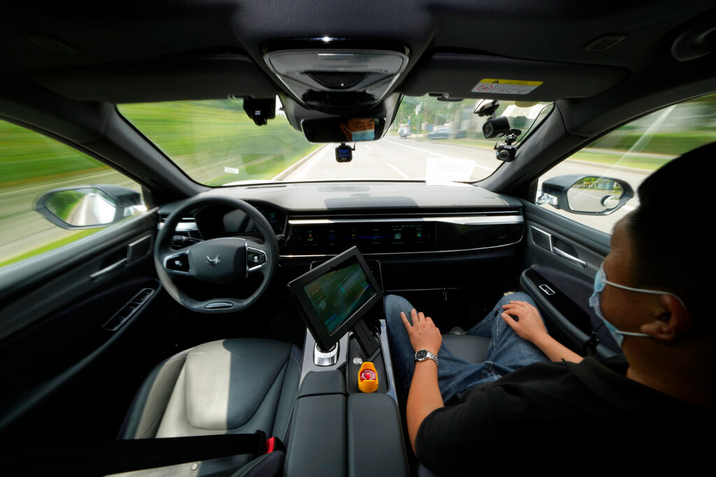A technician monitors the self-driving taxi developed by tech giant Baidu Inc. on June 14, 2022, in Beijing. (AP Photo/Ng Han Guan)