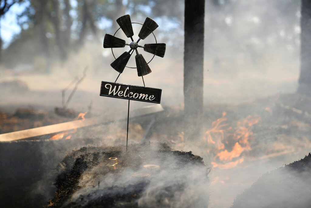 A welcome home sign sits at the front gate of a home along Troost Trail, that was saved by firefighters from the Rices Fire on Tuesday, June 28, 2022, in California's Nevada County. (Elias Funez/The Union via AP)