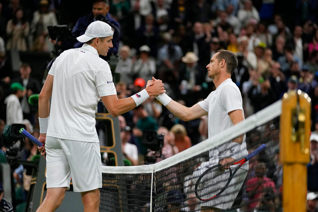John Isner shakes hands with Britain's Andy Murray after defeating him in their singles tennis match on day three of the Wimbledon championships in London, Wednesday, June 29, 2022. (AP Photo/Alastair Grant)