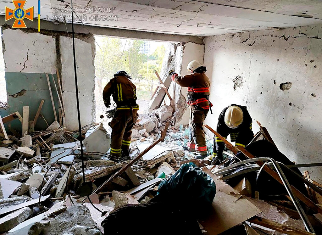 First responders work in a damaged residential building in Odesa, Ukraine, early Friday, July 1, 2022, following Russian missile attacks. (Ukrainian Emergency Service via AP)