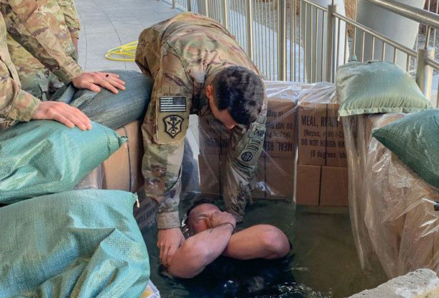 Capt. Christopher Davis, a chaplain with the 82nd Airborne Division, baptizes a paratrooper in Poland, using MRE boxes with a liner. (U.S. Army Chaplain Corps)
