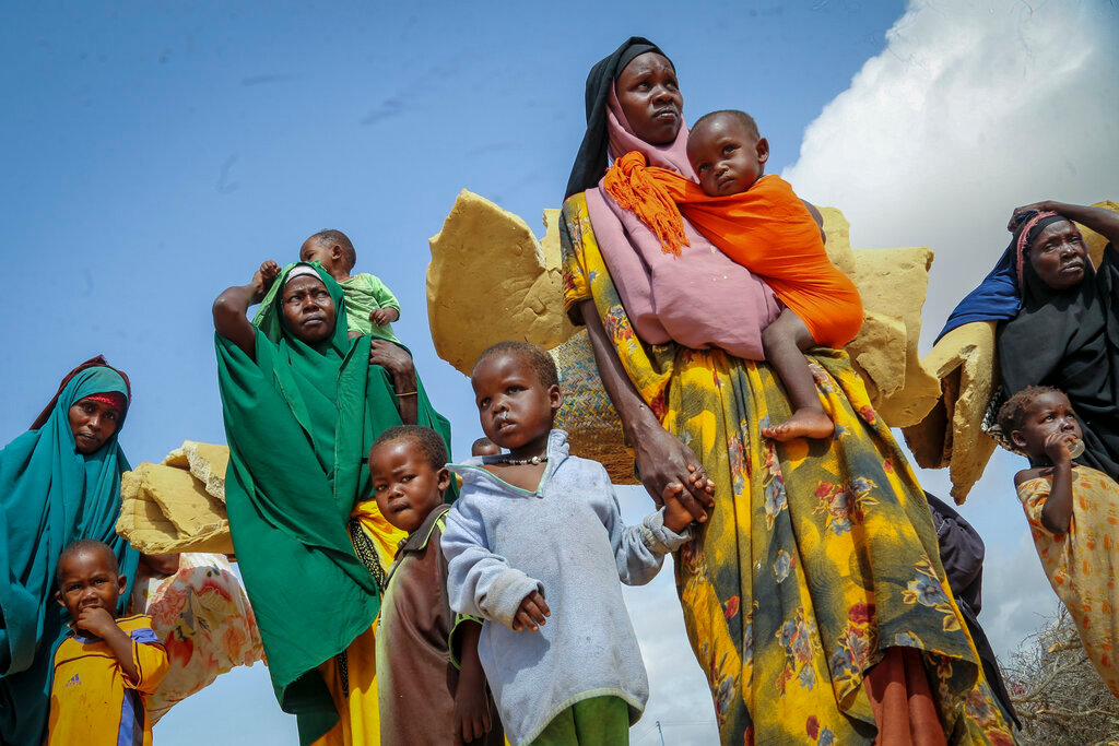 Somalis who fled drought-stricken areas carry their belongings as they arrive at a makeshift camp for the displaced on the outskirts of Mogadishu, Somalia Thursday, June 30, 2022. The war in Ukraine has abruptly drawn millions of dollars away from longer-running humanitarian crises and Somalia is perhaps the most vulnerable as thousands die of hunger amid the driest drought in decades. (AP Photo/Farah Abdi Warsameh)
