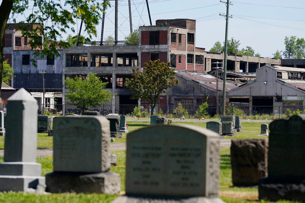 The Packard Plant is seen behind the Trinity Cemetery on Detroit's east side, June 30, 2022. (AP Photo/Carlos Osorio)