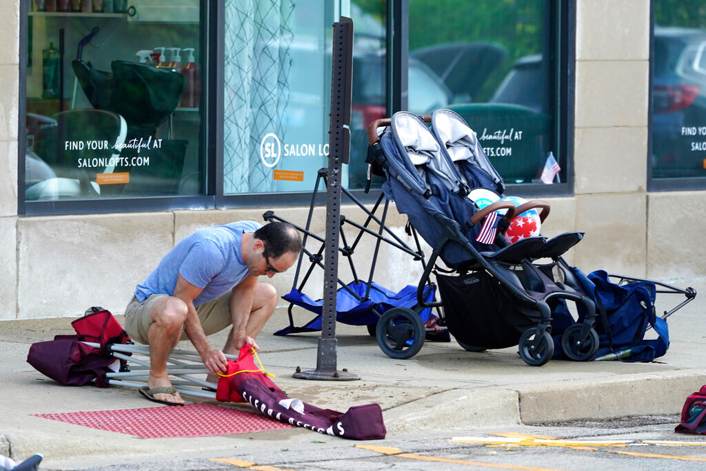 Elliot Lieberman gathers his folding chairs one day after a mass shooting in downtown Highland Park, Ill. Tuesday, July 5, 2022. (AP Photo/Charles Rex Arbogast)