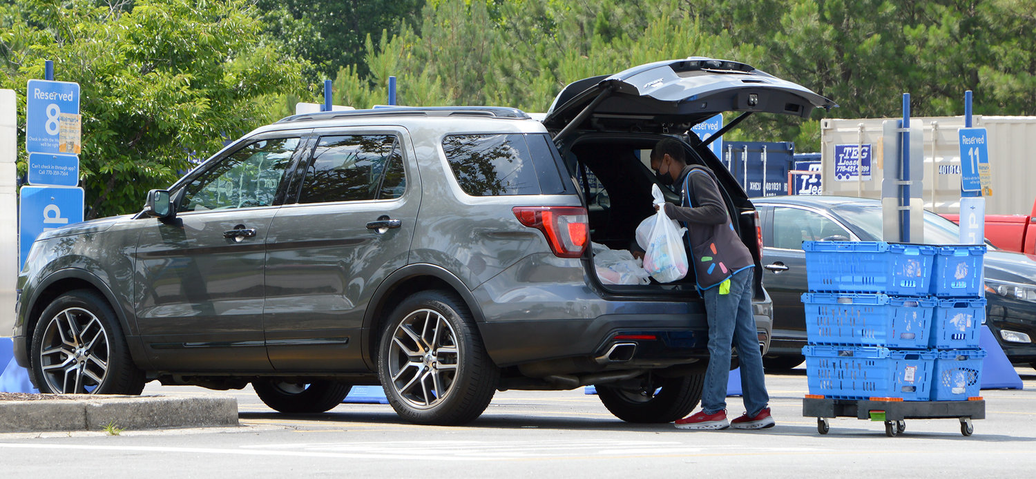 A Walmart employee loads a curbside pickup order into a customer's vehicle June 5, 2022, in Dallas, Ga. (Christian Index/Henry Durand, File)