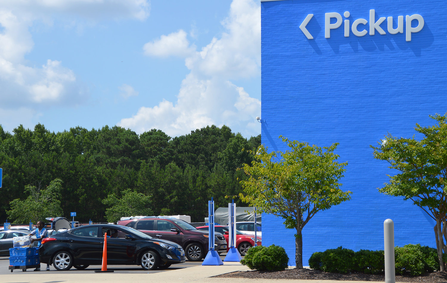 A Walmart employee loads a curbside pickup order into a customer's vehicle June 5, 2022, in Dallas, Ga. (Christian Index/Henry Durand, File)