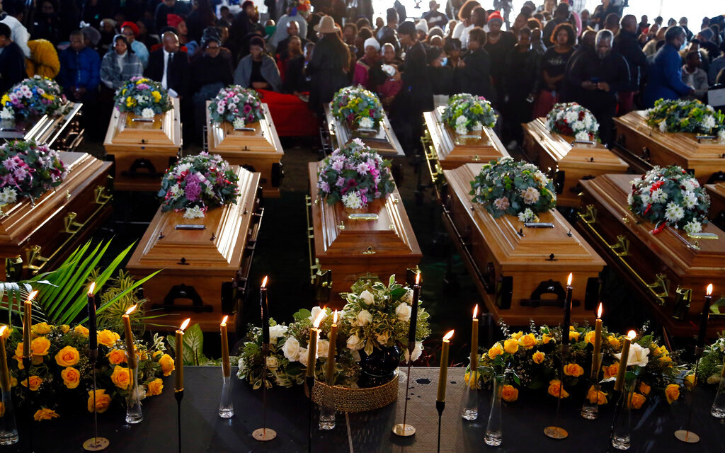 Coffins are lined up during a funeral service for 21 teenagers who died in a mysterious tragedy at a nightclub nearly two weeks ago, in Scenery Park, East London, South Africa, Wednesday, July 6, 2022. (AP Photo)