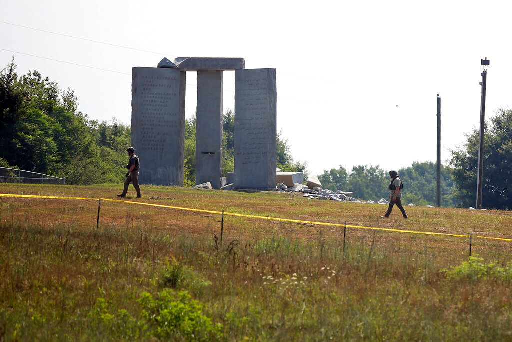 Law enforcement officials walk around the damaged Georgia Guidestones monument near Elberton, Ga., on Wednesday, July 6, 2022. (Rose Scoggins/The Elberton Star via AP)