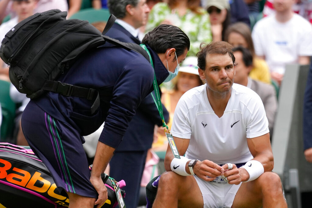 Spain's Rafael Nadal receives treatment just before a medical timeout as he plays Taylor Fritz of the US in a men's singles quarterfinal match at the Wimbledon tennis championships in London, Wednesday, July 6, 2022. (AP Photo/Kirsty Wigglesworth)