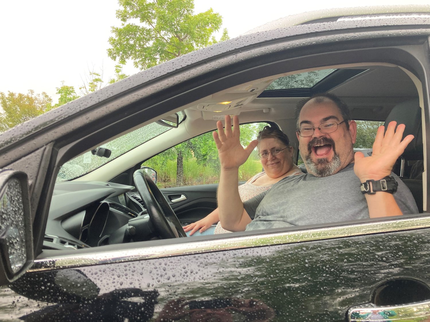 Shane Dixon and his wife, Jenny, celebrate inside the SUV an anonymous donor had given them to drive to First Baptist Church in Peachtree City. (Index/Roger Alford)