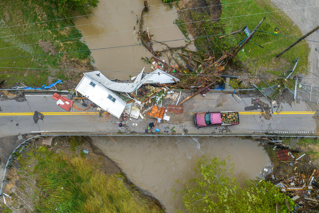 People work to clear a house from a bridge near the Whitesburg Recycling Center in Letcher County, Ky., on Friday, July 29, 2022. (Ryan C. Hermens/Lexington Herald-Leader via AP)