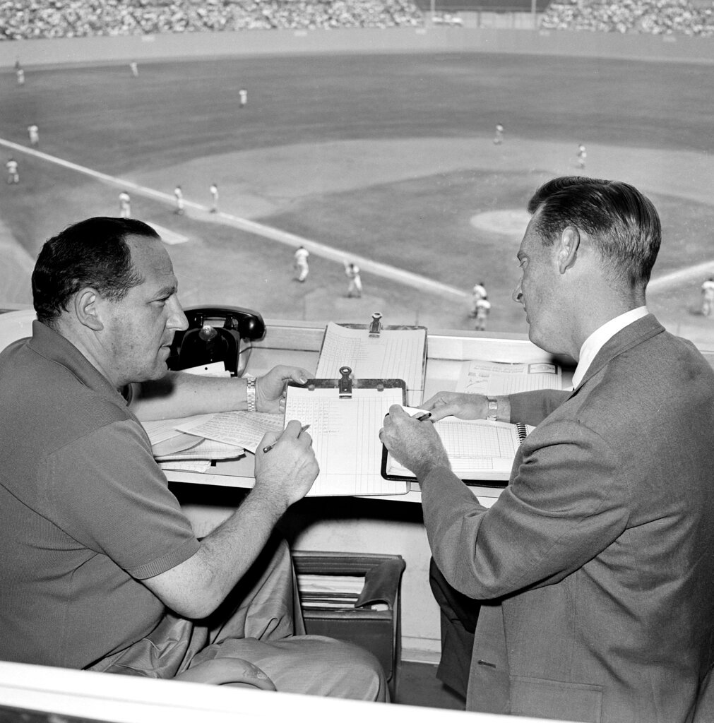 Allan Roth, left, statistician of the Los Angeles Dodgers, sits in the booth with broadcaster Vin Scully in August 1963 in Los Angeles. (AP Photo/Harold Filan, File)