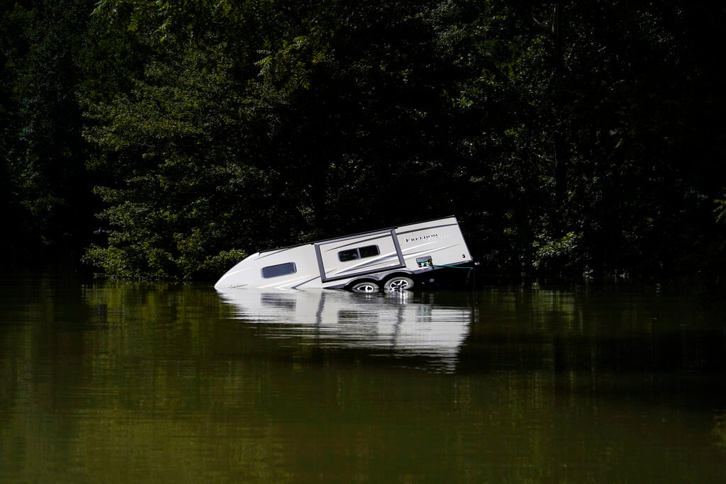 A camper is seen partly submerged in Carr Creek Lake on Wednesday, Aug. 3, 2022, near Hazard, Ky. (AP Photo/Brynn Anderson)