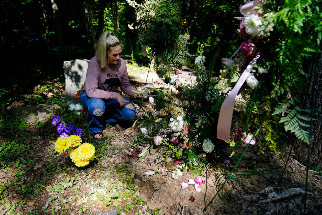 Angel Campbell, visits the grave of her grandmother, Nellie Mae Howard, on Thursday, Aug. 4, 2022, in Chavies, Ky. (AP Photo/Brynn Anderson)
