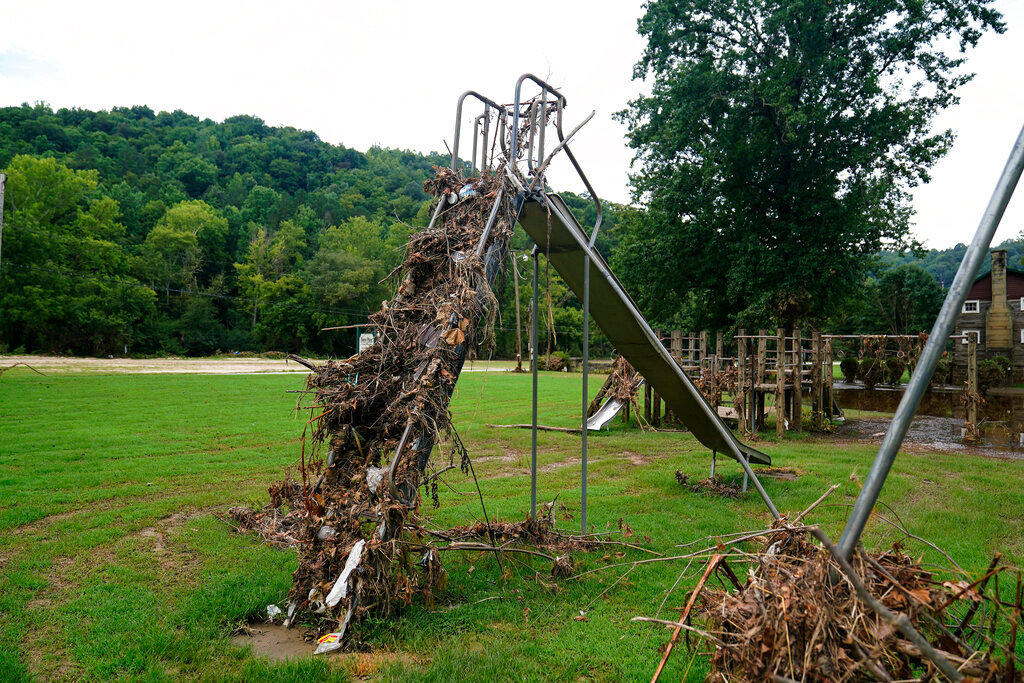 Debris gathers atop a slide in a children's play area after last week's massive flooding near Haddix, Ky., Friday, Aug. 5, 2022. (AP Photo/Brynn Anderson)
