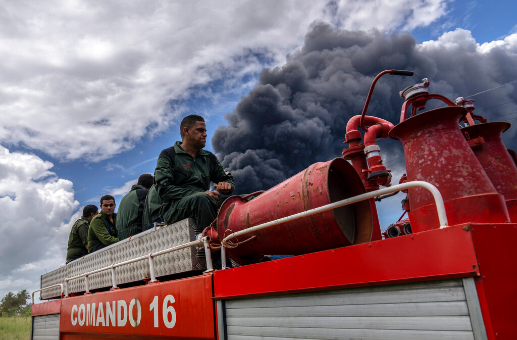 Firefighters head into the Matanzas supertanker base to douse a fire that started during a thunderstorm, in Matanzas, Cuba, Sunday, Aug. 7, 2022. (AP Photo/Ramon Espinosa)