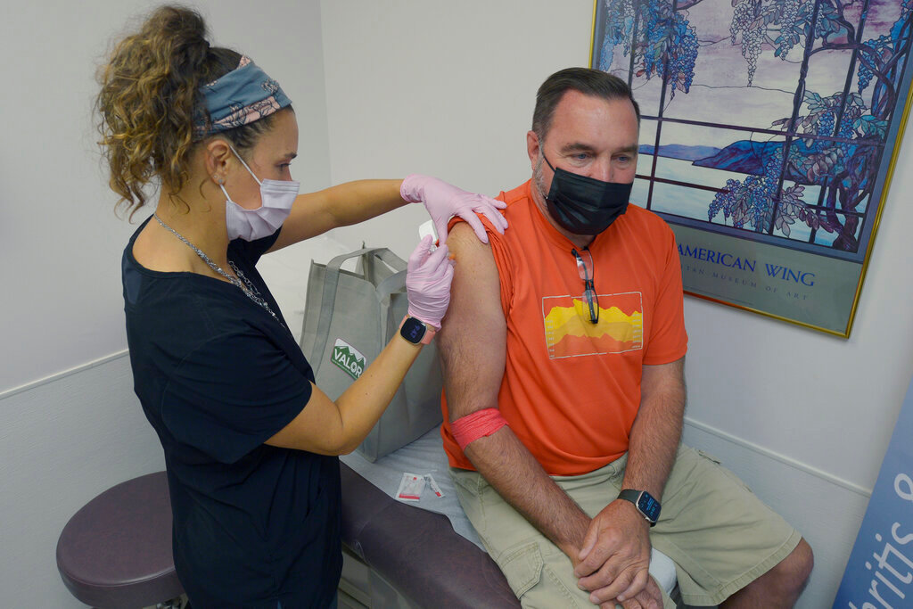 Registered nurse Janae Roland injects Robert Terwilliger, right, of Williamsburg, Pa., as part of a Lyme disease vaccine trial at the Altoona Center for Clinical Research, Friday, Aug. 5, 2022, in Duncansville, Pa. (AP Photo/Gary M. Baranec)