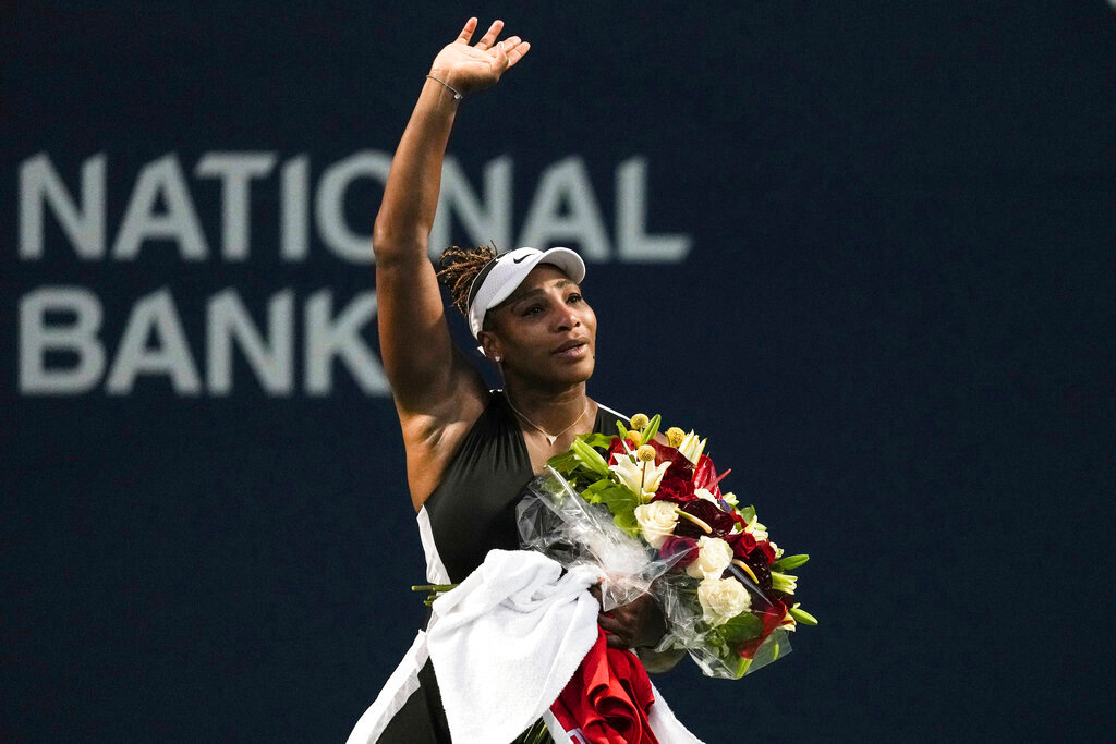 Serena Williams leaves the court carrying flowers and waving to fans after her loss to Belinda Bencic, of Switzerland, at the National Bank Open tennis tournament Wednesday, Aug. 10, 2022, in Toronto. (Chris Young/The Canadian Press via AP)