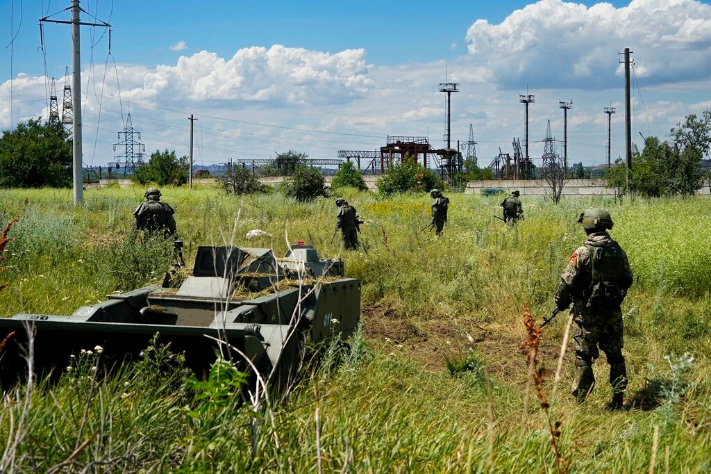 Russian mine-clearing experts work to find and defuse mines along the high voltage line in Mariupol, on the territory which is under the Government of the Donetsk People's Republic control, eastern Ukraine, July 13, 2022. (AP Photo, File)
