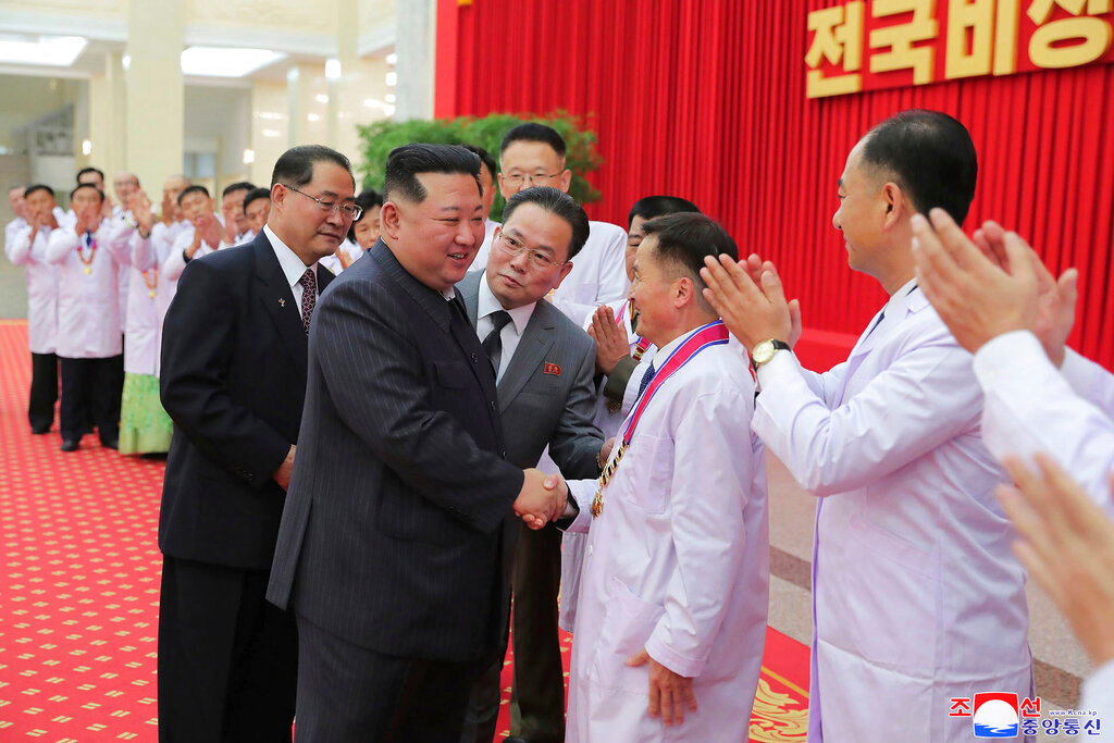 North Korean leader Kim Jong Un shakes hands with a health official in Pyongyang, North Korea, Wednesday, Aug. 10, 2022. Kim has declared victory over COVID-19 and ordered an easing of preventive measures. (Korean Central News Agency/Korea News Service via AP)